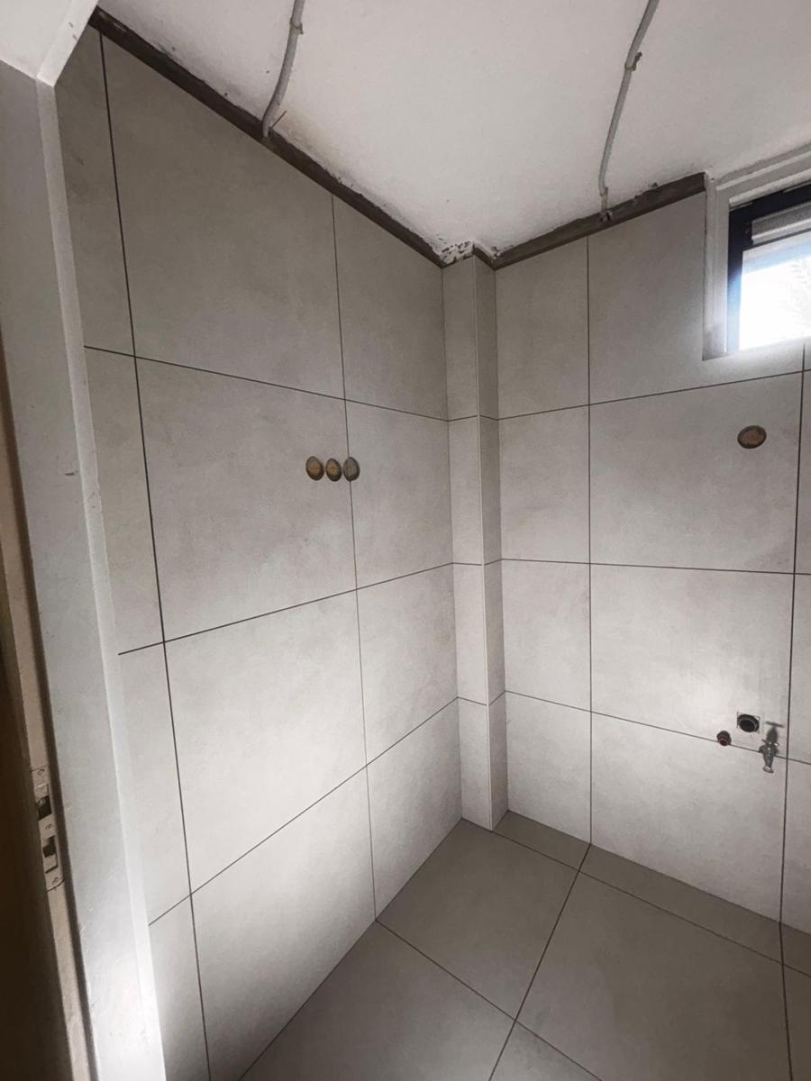 Badkamer met lichtgrijze grootformaat wandtegels en grijze vloertegels